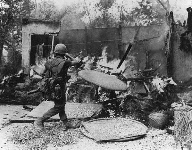 A soldier burning down a hut in My Lai village, Vietnam.