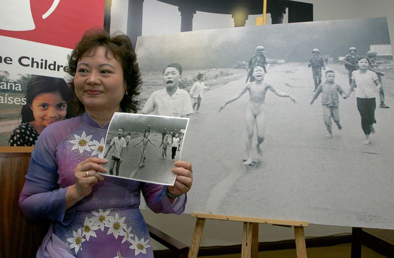 Phan Thị Kim Phúc, also known as "Napalm Girl," poses with the iconic photo taken in Trang Bang by AP photographer Nick Ut which showed her at nine years of age running naked on a road after being severely burned by a South Vietnamese napalm attack.