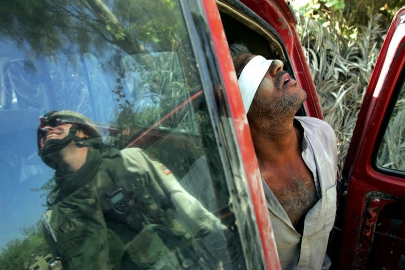 An Iraqi man suspected of having explosives in his car is held after being arrested by the U.S army near Baquba.