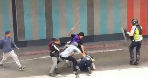 Un grupo de la derecha venezolana golpeando a funcionario policial.