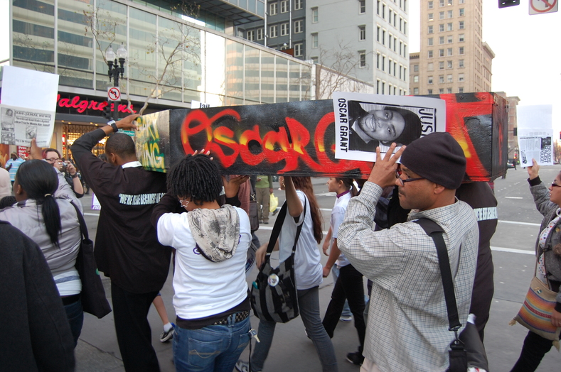 Demonstrators carry mock casket for Oscar Grant, shot by BART police New Year