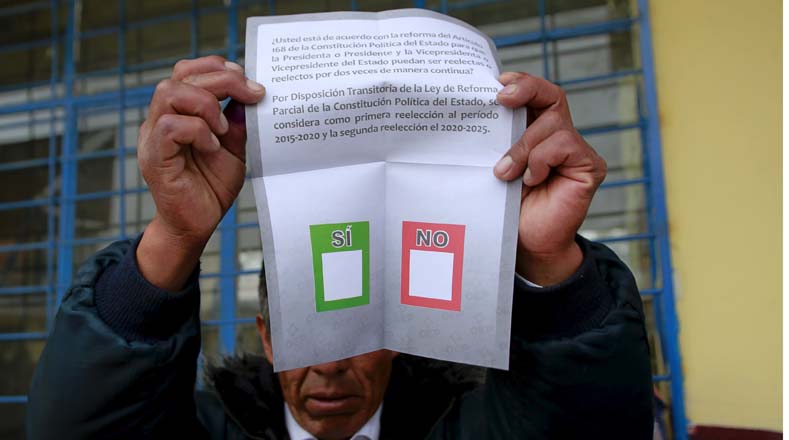 Un miembro de la comisión electoral muestra la boleta que se está usando en el referendo.
