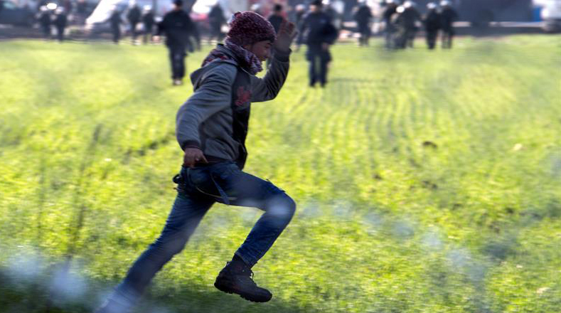 Ciudadano sirio escapa de los agentes policiales macedonios.