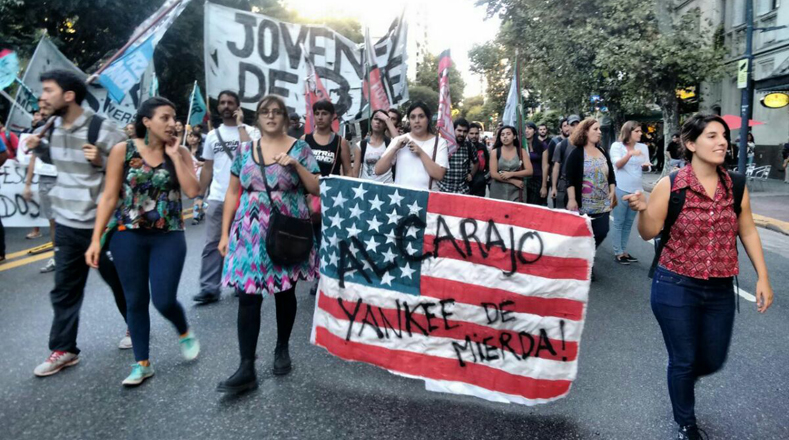 Jóvenes argentinas portan una bandera estadounidense donde se lee "ALCAarajo".