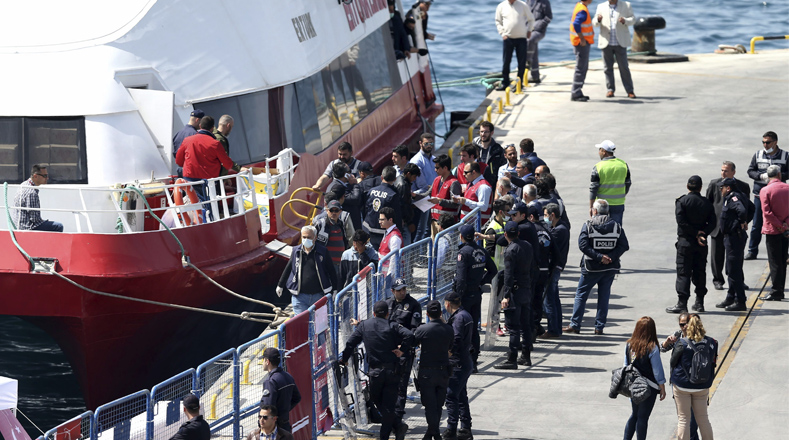 Autoridades turcas reciben a los refugiados en el puerto turco de Dikili. 