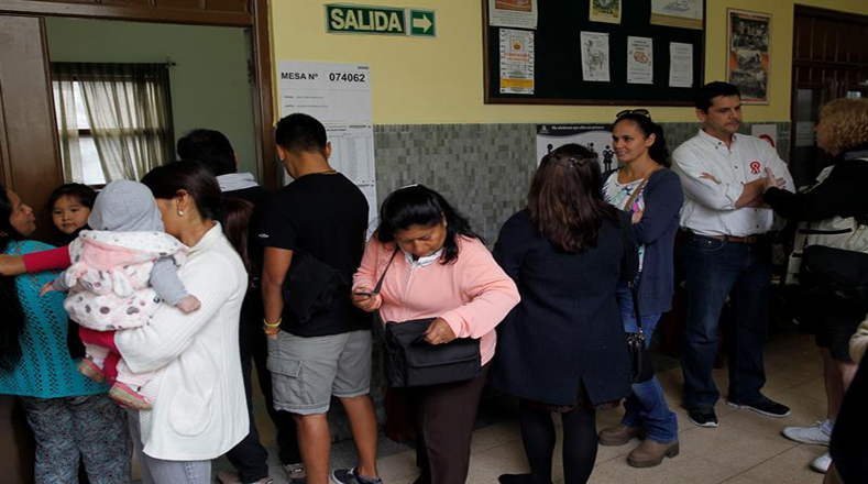 Ciudadanos peruanos hacen fila para votar en la Parroquia de Los Migrantes de Montevideo en Uruguay.
