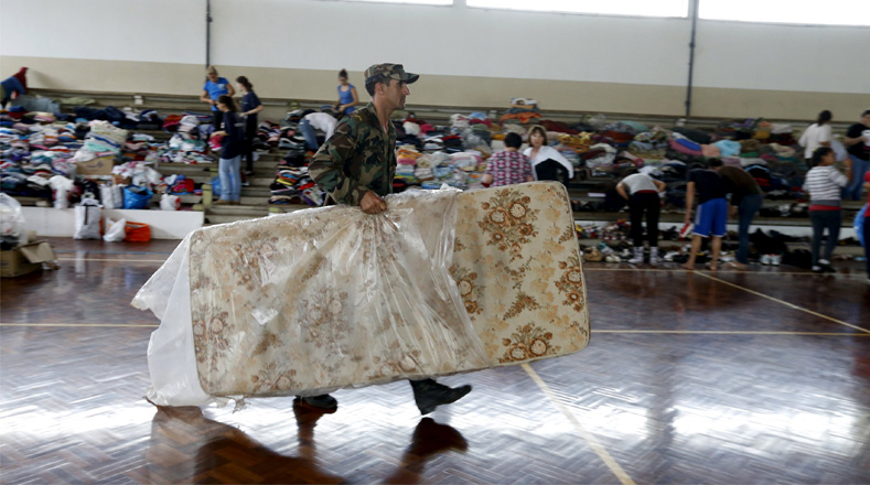Un soldado lleva un colchón en un refugio temporal en un gimnasio público en Dolores.