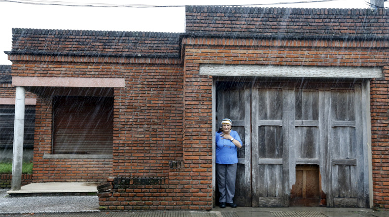 Una mujer observa como cae la lluvia después del fuerte temporal del pasado sábado. 