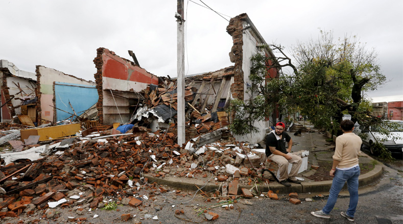 Un día después del tornado que afectó a la ciudad de Dolores, personas observan los estragos. 