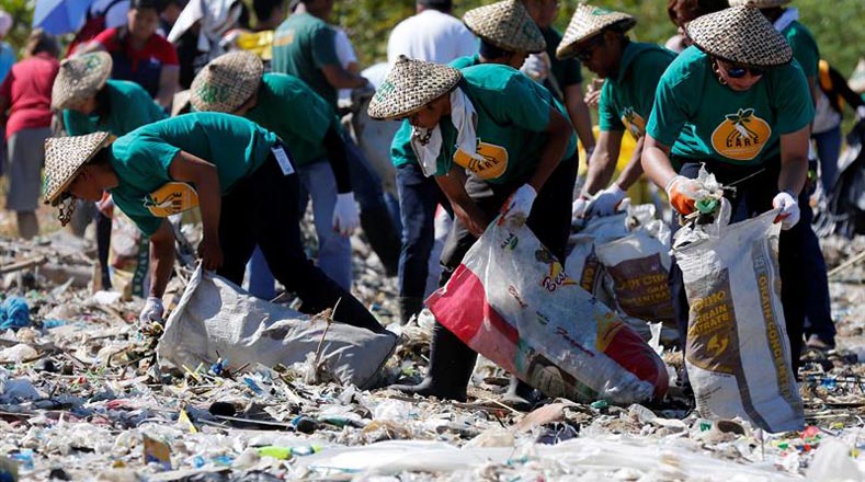 Ambientalistas filipinos recogen basura en la Isla de la Libertad.