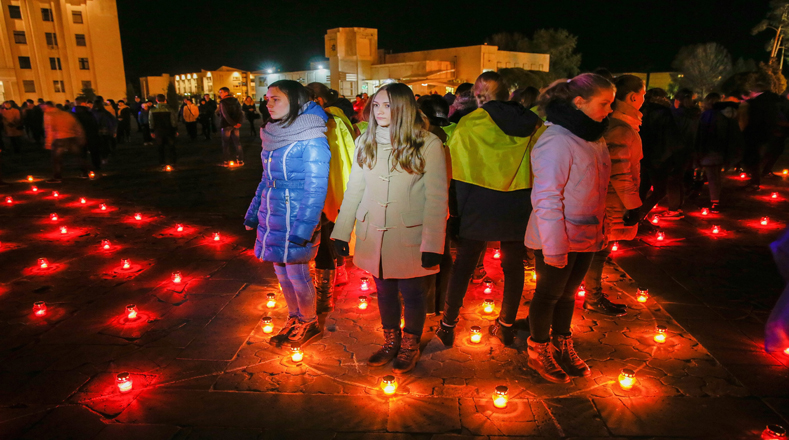 Ucranianos encienden velas cerca del monumento a los Héroes de Chernóbil durante una ceremonia en honor a los "Liquidadores" quienes murieron durante los trabajos de limpieza.
