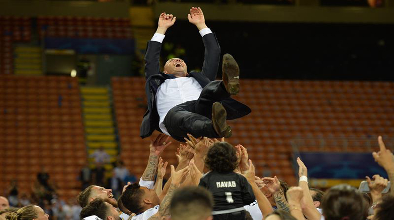 Los jugadores celebran lanzando al aire al entrenador Zinedine Zidane, quien gana su primera Champions como primer entrenador del Madrid.