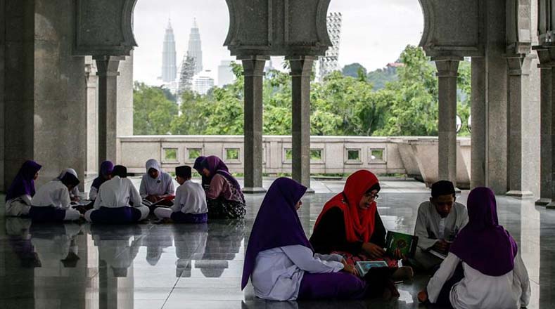 Estudiantes leen el Corán en compañía de su profesora en la Mezquita del Territorio Federal en Kuala Lumpur (Malasia).