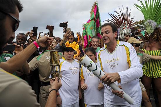 El alcalde de Río de Janeiro, Eduardo Paes, el primero de casi 600 personas, recibió e inició el recorrido de la antorcha por la ciudad anfitriona de los juegos.