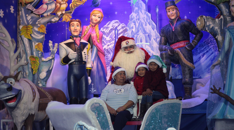 La figura de Papá Noel o San Nicolás es universal, una familia posa en el carruaje de Papá Noel como parte de las tradiciones y festejos navideños en Ciudad de México. 