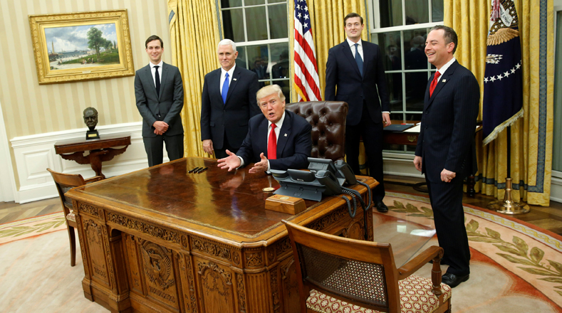 El presidente de Estados Unidos, Donald Trump, acompañado por el asesor, Jared Kushner, el vicepresidente Mike Pence, el secretario del personal, Rob Priebus, quienes le dan la bienvenida a la prensa en la Oficina Oval para firmar las primeras órdenes ejecutivas en la Casa Blanca en Washington.