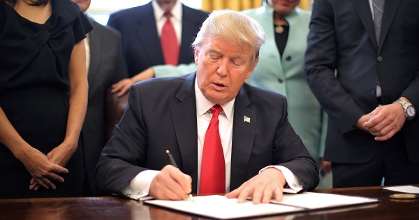 U.S. President Donald Trump signs an executive order cutting regulations at the Oval Office of the White House in Washington, Jan. 30, 2017.