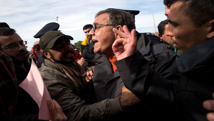 El ministro de Inmigración, Yannis Mouzalas (centro), encara a un conjunto de manifestantes inmigrantes