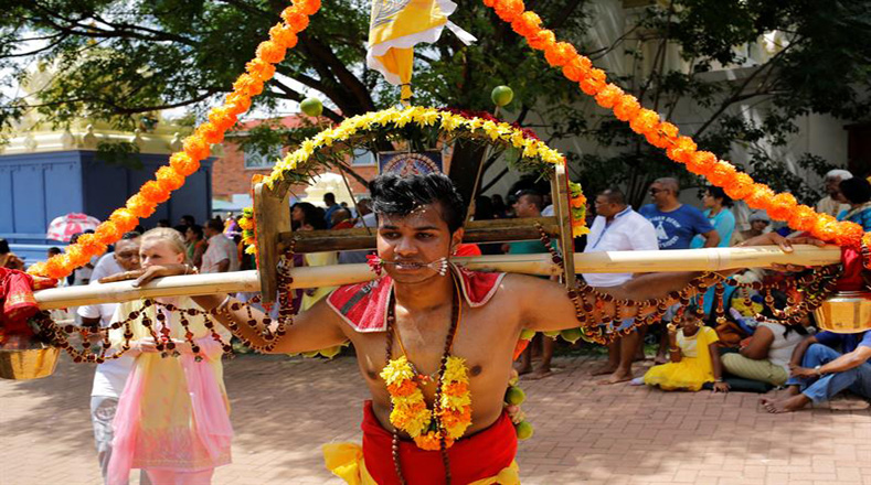 Los devotos llevan kavadis, o cargas físicas, y participan en una larga procesión, a menudo comenzada antes del amanecer, para honrar al dios hindú Murugan y pedir favores o perdón.
