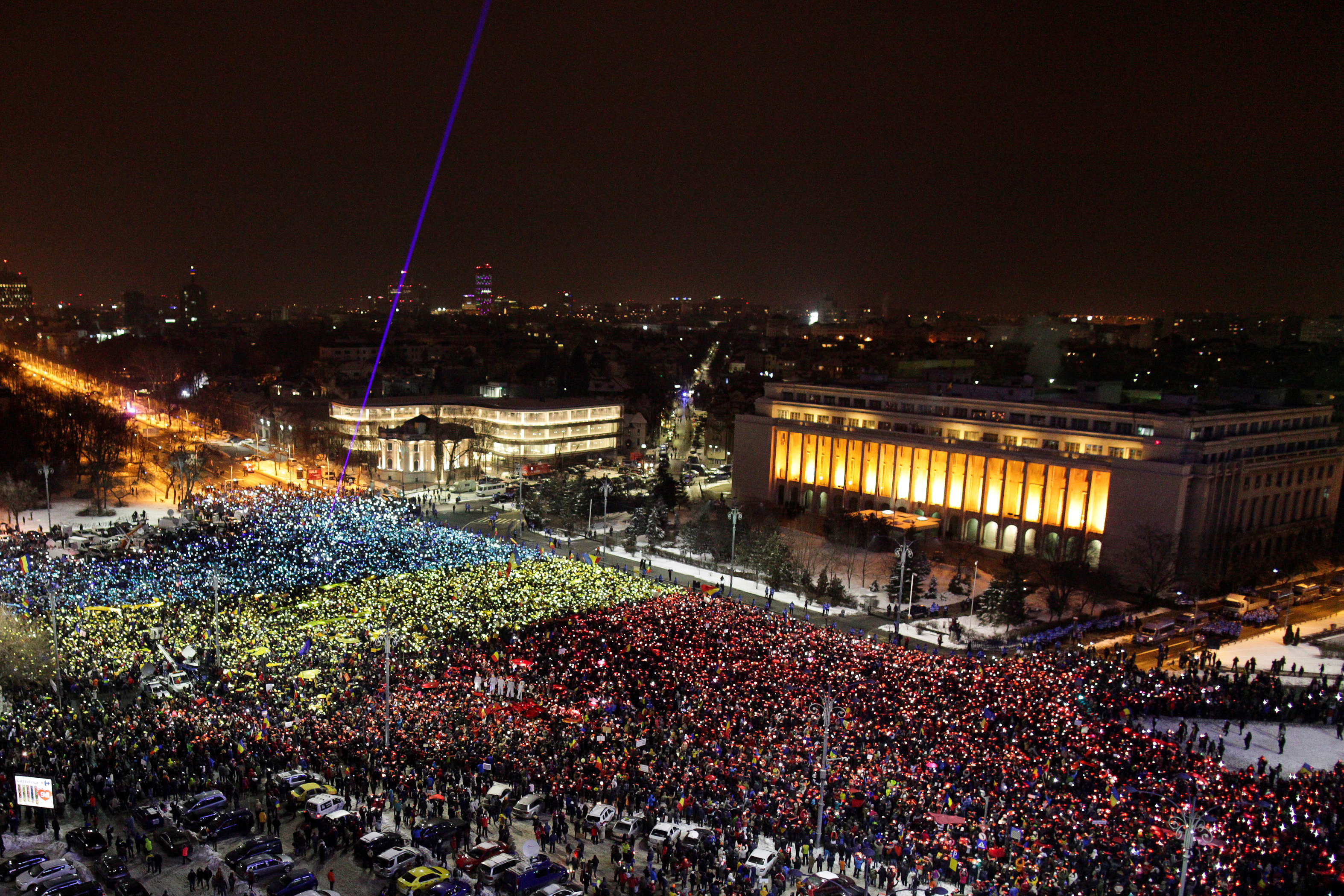 Rumanos levantaron trozos de papel de color rojo, amarillo y azul sobre sus cabezas para formar una bandera rumana gigante.