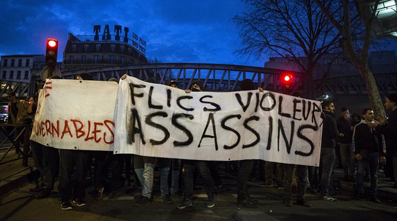 Varias personas sostienen una pancarta en la que se lee "Policías, violadores, asesinos".