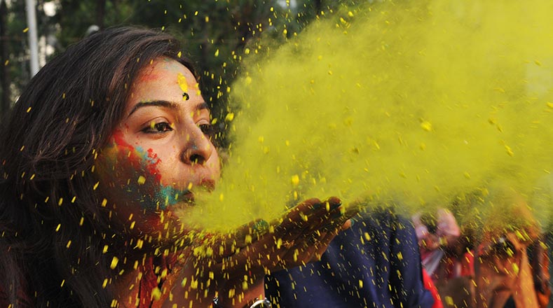 Los asistentes juegan a lanzarse polvos de colores en las calles de la India para rendir culto al dios Vishnú y su avatar Krishna.