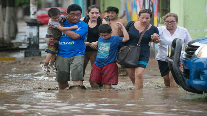 Residentes cruzan una calle inundada en Trujillo, al norte de Perú.