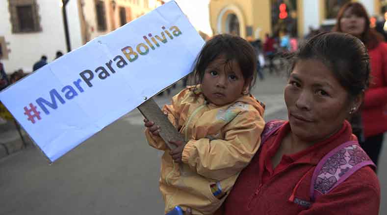 Una niña sostiene un cartel con la etiqueta #MarParaBolivia