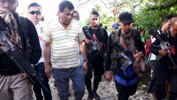 President of the Philippines, Rodrigo Duterte, walks with rebels from the New People