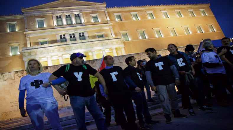 Un grupo de manifestantes trató de impedir que continuaran los disturbios en el Parlamento griego durante la votación de los legisladores en la última ronda de recortes en Grecia.