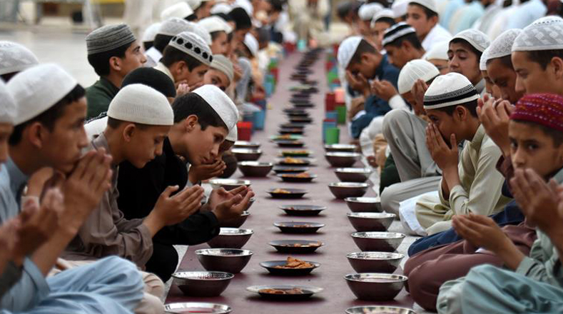 En Pakistán lo musulmanes rezan antes de comenzar a comer, durante el primer día del mes de Ramadán.