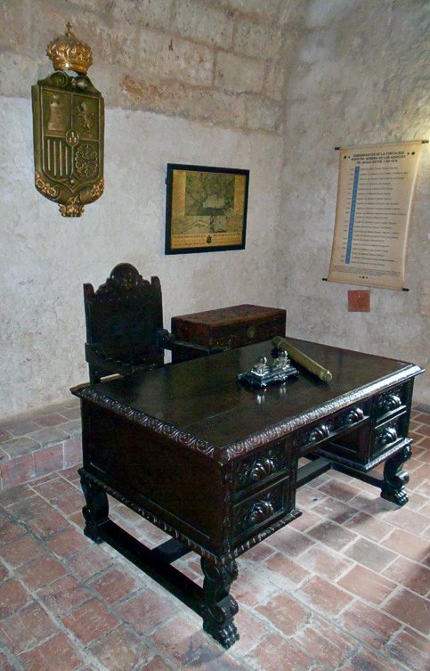 En una de las salas abovedadas se encuentra la oficina del comandante, ambientada con un juego de escritorio estilo Renacimiento Español, entre otras piezas que armonizan con el entorno oficial.