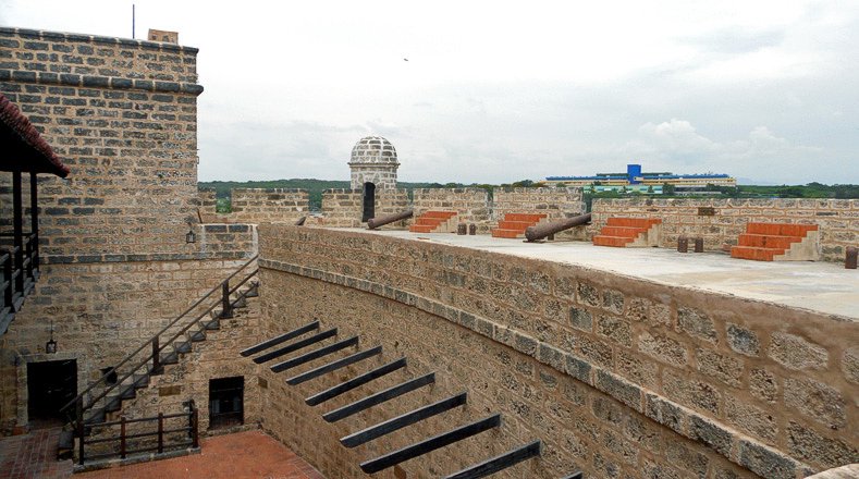 Una escalera sirve de acceso desde el patio central interior a la batería de cañones situada en las almenas de la fortaleza. Debajo de la citada escala se observa la entrada al calabozo.