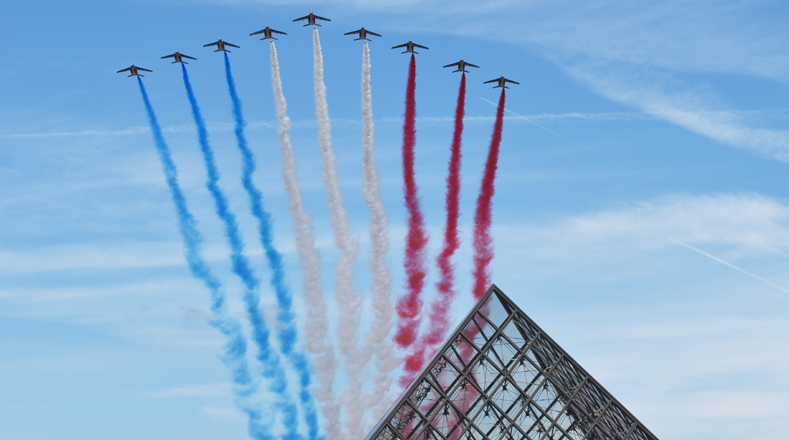 Aviones de la Patrulla Acrobática de Francia vuelan sobre la Pirámide del Museo Louvre.