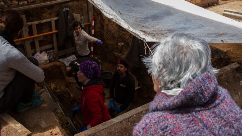 Ascensión Mendieta mira el trabajo que hacen los arqueólogos y voluntarios en la fosa.