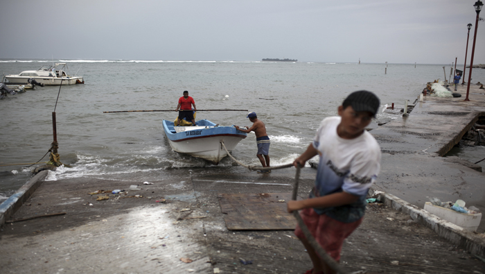 Un grupo de pescadores sacaban un bote del mar mientras se preparaban para la llegada de Franklin en el puerto de la ciudad de Veracruz.