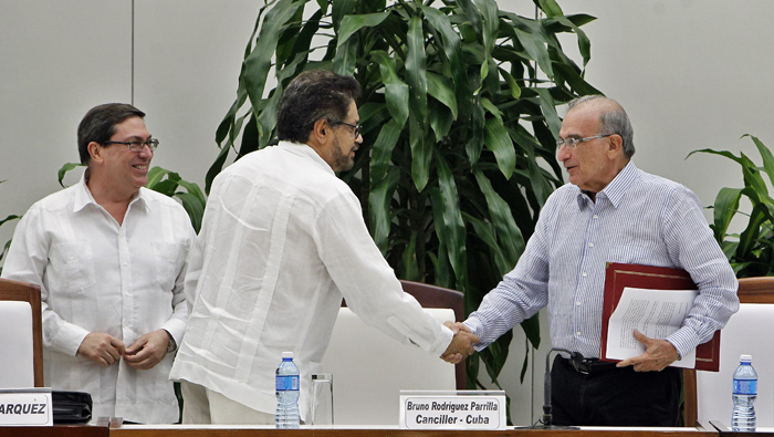 El jefe negociador del Gobierno colombiano, Humberto de la Calle (d), saluda al segundo jefe de las FARC-EP, Luciano Marín (c), alias 