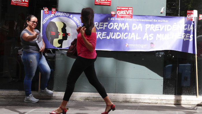 Mujeres brasileñas entregan volantes en contra de la reforma jubilatoria.