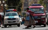 Una mujer cruza una calle este lunes en La Paz, Bolivia, en el marco de la flexibilización del confinamiento social.