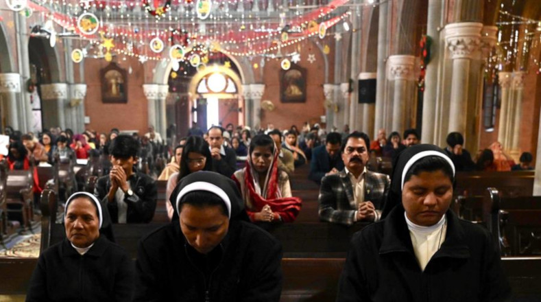 En Pakistán, la comunidad cristiana asiste a una misa de Navidad en una iglesia en Lahore, juntándose alrededor del símbolo del nacimiento de Jesucristo.