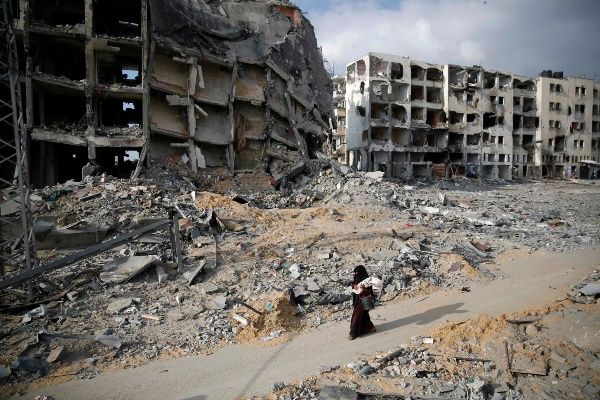 A Palestinian woman walks past buildings destroyed by what police said were Israeli air strikes and shelling in the town of Beit Lahiya in the northern Gaza Strip August 3, 2014. (Photo: Reuters)