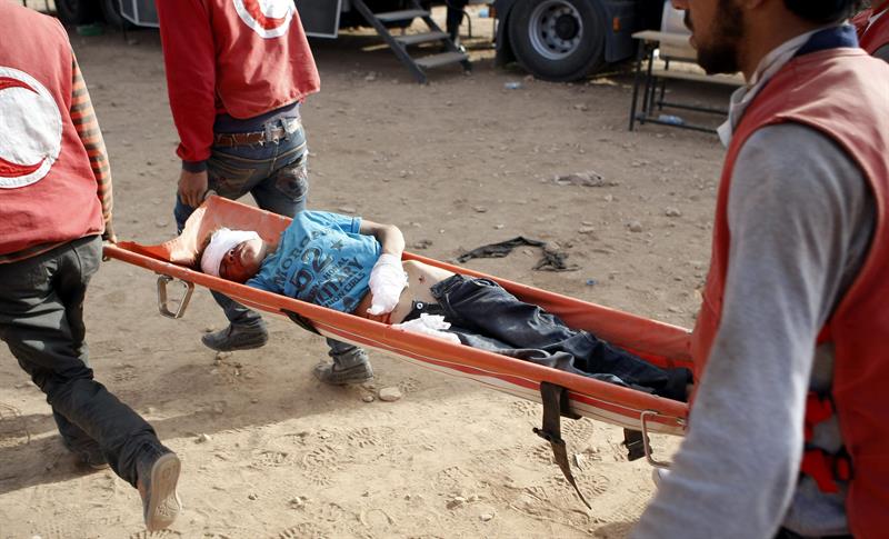 Miembros de la Media Luna Roja trasladan a un niño herido en la frontera turco-siria tras los bombardeos de este miércoles. (Foto: EFE)
