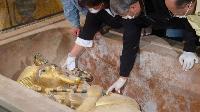 Un grupo de arqueólogos observa la réplica del faraón Tutankamón.