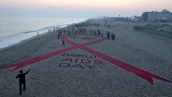 En una playa peruana defensores de los derechos humanos revelaron una escultura de arena de un lazo rojo para crear conciencia sobre el contagio del SIDA. 