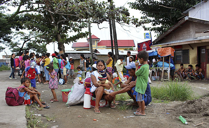 Residentes esperan los vehículos gubernamentales que los llevarán Tecloban, centro del país, por la llegada del tifón Hagupit.