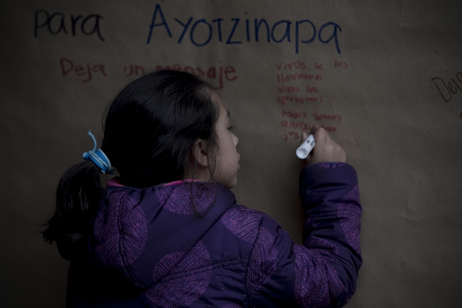 Una niña escribe un mensaje durante el homenaje luctuoso y misa en memoria de Julio César Mondragón Fontes, estudiante de la Normal Rural de Ayotzinapa quien perdió la vida en los hechos del 26 de septiembre en Iguala.