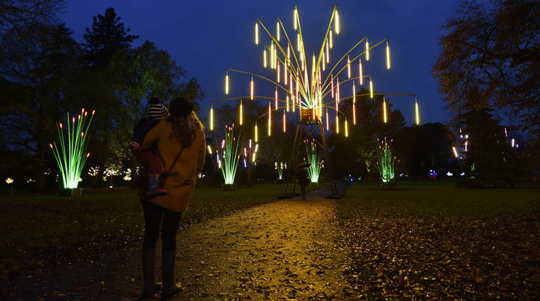 Una madre junto a su hijo observan el espectáculo de luces que adornan una plaza de Inglaterra. 