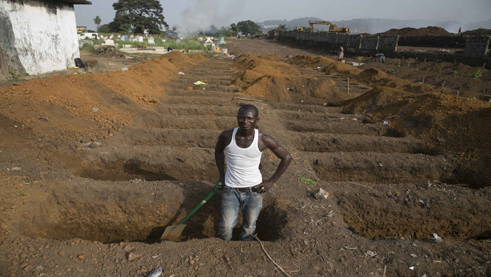 Un trabajador del cementerio de Freetown habilita nuevas fosas para las víctimas mortales del virus.