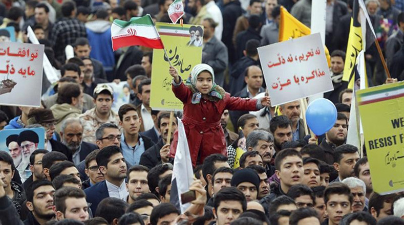 Entre la multitud que celebraba el 36 aniversario de la Revolución Islámica resalta una niña que ondea la bandera nacional.