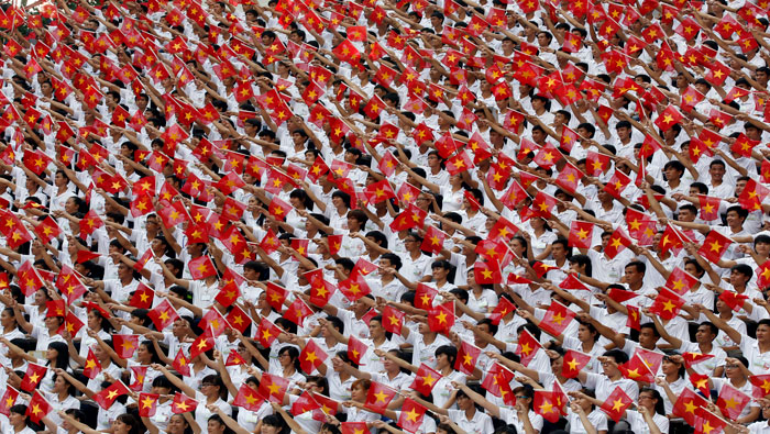 Estudiantes vietnamitas ondean banderas en desfile cívico-militar